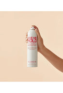 Hand holding a can of 'Give Me Hold Flexible Hairspray' by Eleven on a beige background - Hair Care Canada