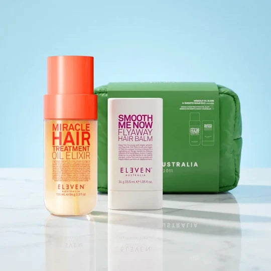 Hair care products including a bottle, balm, and pouch on a reflective surface with a light blue background.