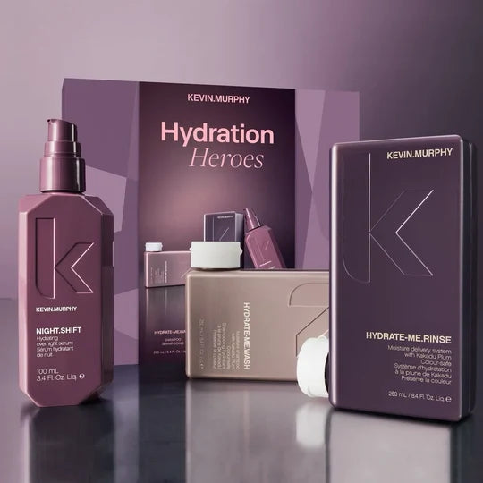 Kevin Murphy Haircare 'Hydration Heroes' gift set featuring a Night-Shift hair serum bottle, a Hydrate-Me Rinse box, and a Hydrate-Me Serum box, arranged in front of a branded display card on a reflective dark surface.