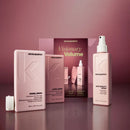 Kevin Murphy Visionary Volume hair care set featuring a pink Angel Wash bottle, Angel Rinse bottle, and Antigravity Spray bottle, alongside a product box, arranged on a reflective surface against a matching pink background.