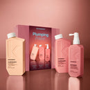 Kevin Murphy Plumping Power hair care set featuring a peach-colored shampoo bottle, a pink conditioner bottle, a pink body mass bottle, and the product box on a matching pink background.