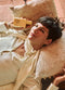 Person lying on a textured pillow holding a wooden object - Hair Care Canada