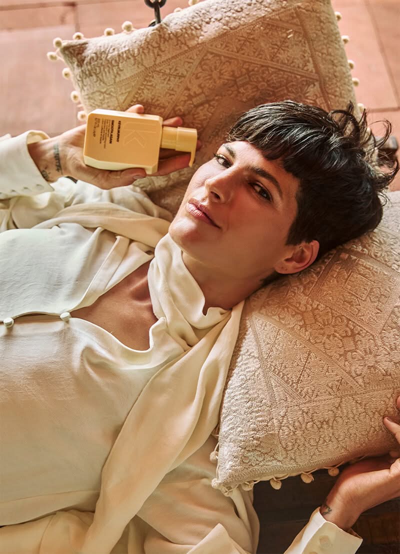 Person lying on a textured pillow holding a wooden object - Hair Care Canada