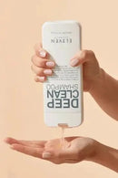 Hand holding a bottle of ELVÉEN Deep Clean Shampoo with liquid being poured onto a palm against a beige background Hair Care Canada