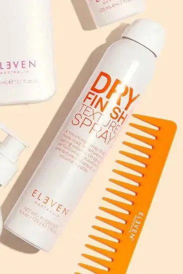 Hair care products including a bottle of 'Dry Finish Texture Spray' and a comb on a beige background Hair Care Canada