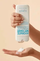 Hand holding a bottle of Elven Moisturize My Hair product with a beige background - Hair Care Canada