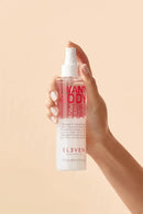 Hand holding a bottle of Eleven NYC Body Texture Spray against a beige background - Hair Care Canada