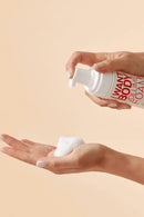 Person holding a bottle of 'Want Body' volume foam with a beige background - Hair Care Canada
