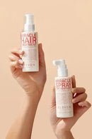 Two bottles of 'Miracle Hair Treatment' and 'Miracle Spray' held by a person against a beige background - Hair Care Canada