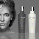 Two Ethica haircare bottles, one dark gray and one white, shown against a dark gray background with a blurred grayscale portrait of a woman on the left.