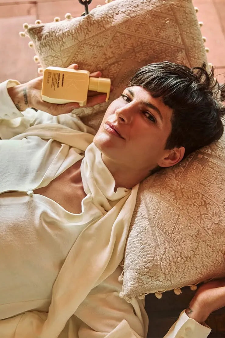 Person lying on a textured pillow holding a wooden object - Hair Care Canada