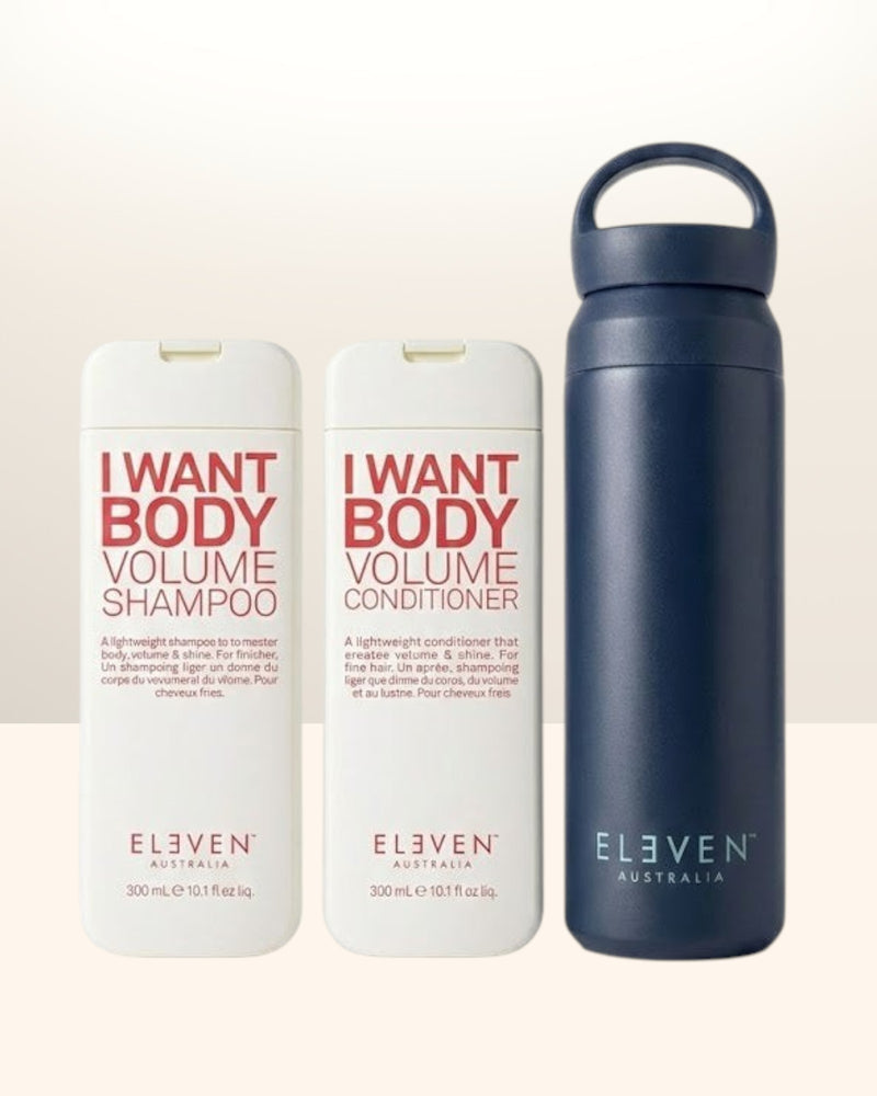 Two bottles of 'I Want Body Volume' shampoo and conditioner by Eleven Australia, with a navy water bottle - Hair Care Canada